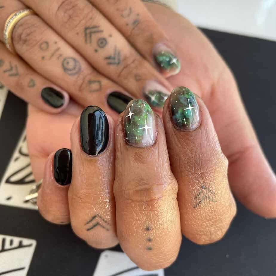 21. Black and green galaxy nails